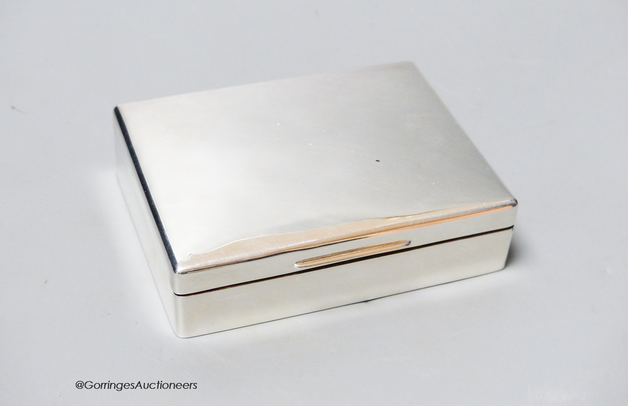 A George V silver mounted cigarette box, marks rubbed, Birmingham, 1924?, 11.4cm.